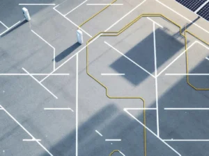 Moderne parkeerplaats met elektrische oplaadstations en zonnepanelen, bovenaanzicht met witte parkeervakken