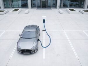 Elektrische auto bij witte laadpaal in moderne parkeergarage met geometrische lijnen en blauwe laadindicator
