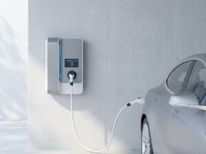 Moderne elektrische auto oplaadstation met witte kabel en digitaal display tegen betonnen muur
