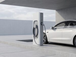 Moderne elektrische voertuig oplaadstation met wit minimalistisch ontwerp en opgerolde oplaadkabel