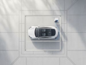 Moderne elektrische auto laadt op bij wit laadstation in minimalistische parkeerplaats met betonnen lijnen