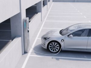 Elektrisch voertuig wordt opgeladen bij moderne laadpaal op betonnen parkeerplaats met minimalistische architectuur