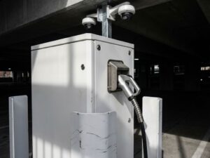 Moderne EV-laadpaal met beveiligingscamera's, versterkte behuizing en vandaalbestendige bevestiging in stedelijke omgeving