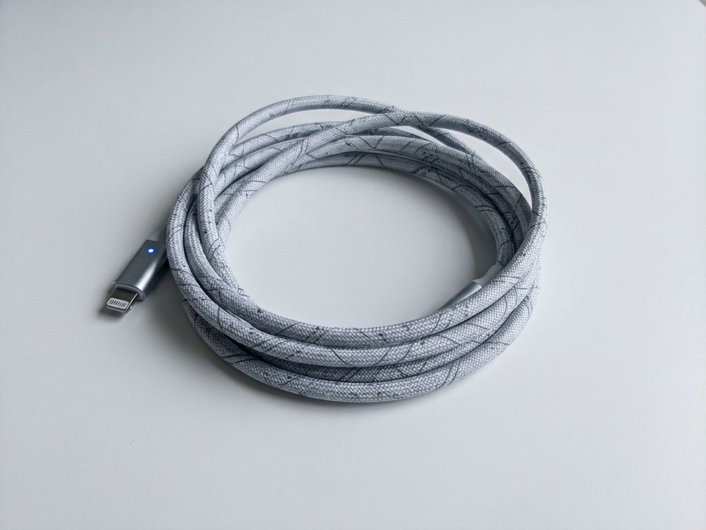 Elegante oplaadkabel met geometrische patronen op witte ondergrond, minimalistische productfotografie met blauwe accenten